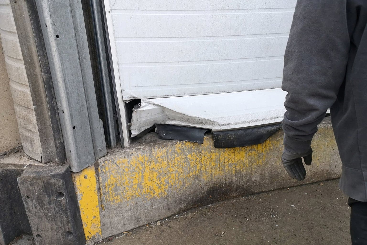 Crushed bottom section and torn seal on a dock door